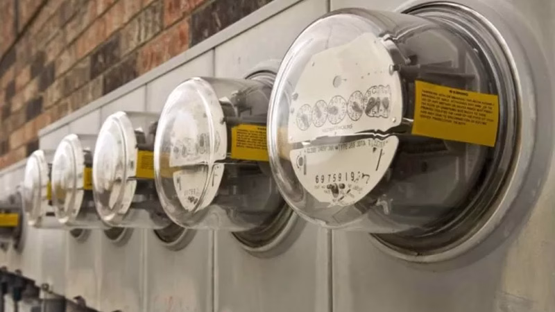 A row of electricity meters mounted on a brick wall, symbolizing energy access and the challenges of affordability for low-income households.